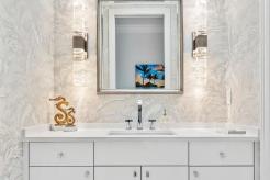 Powder room design, combining classic white cabinets with sleek, contemporary slab glossy doors. Elegant sconces coordinate perfectly with the handles, while exquisite, delicate wallpaper adds a touch of sophistication! 🤍